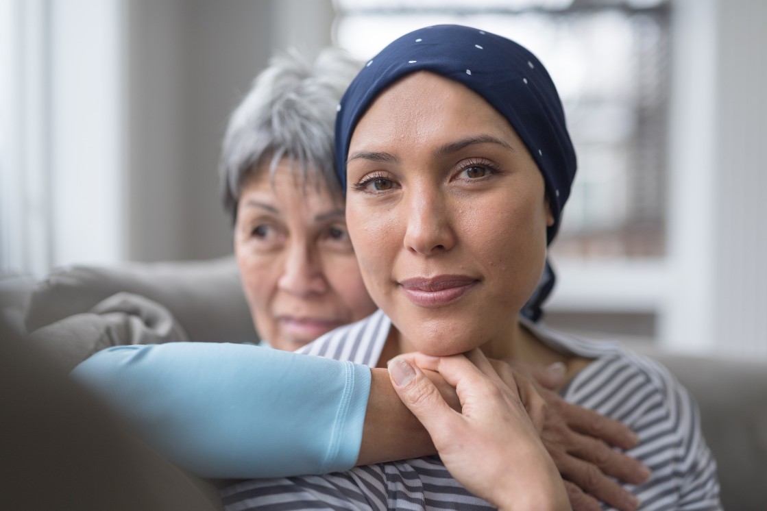 Woman getting support from loved one during cancer treatment. 