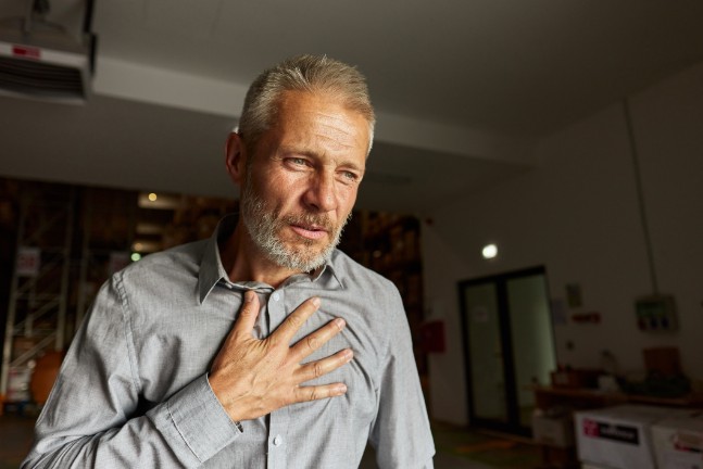 man holding chest, chest pain