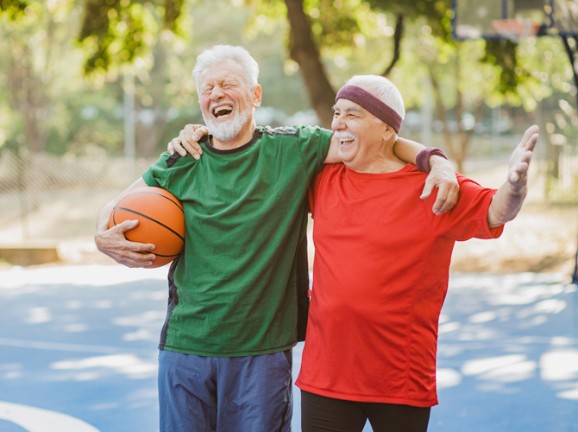Two senior men enjoy a game of basketball