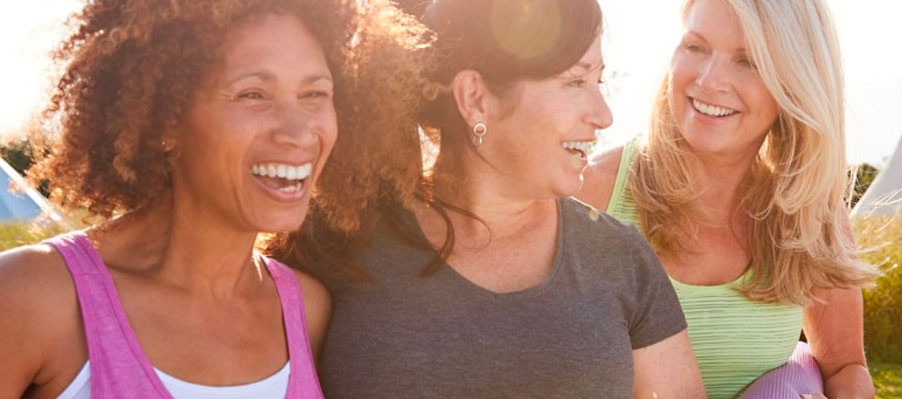Middle-aged women in a group talking and laughing, in workout clothes