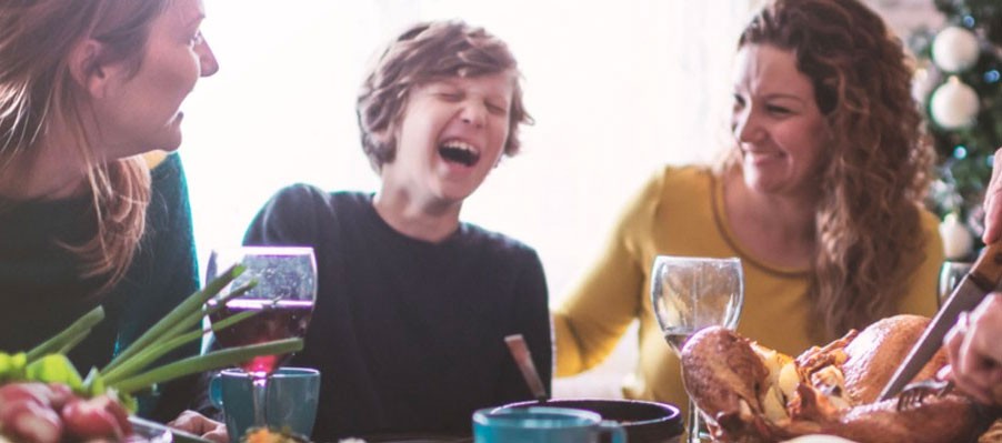 Thanksgiving meal with young boy laughing