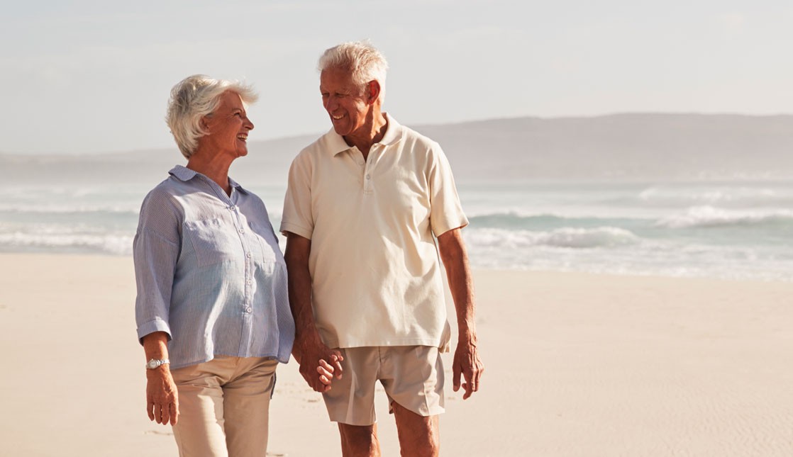 Seniors walking along the beach.
