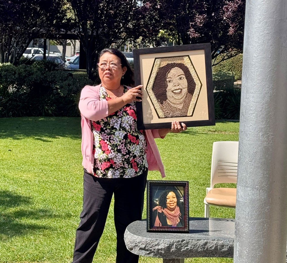 One Legacy ambassador Rita Jackson holds up a floragraph she created, featuring her daughter Jasmine during a flag-raising ceremony on Thursday, April 30, to mark Donate Life Month.