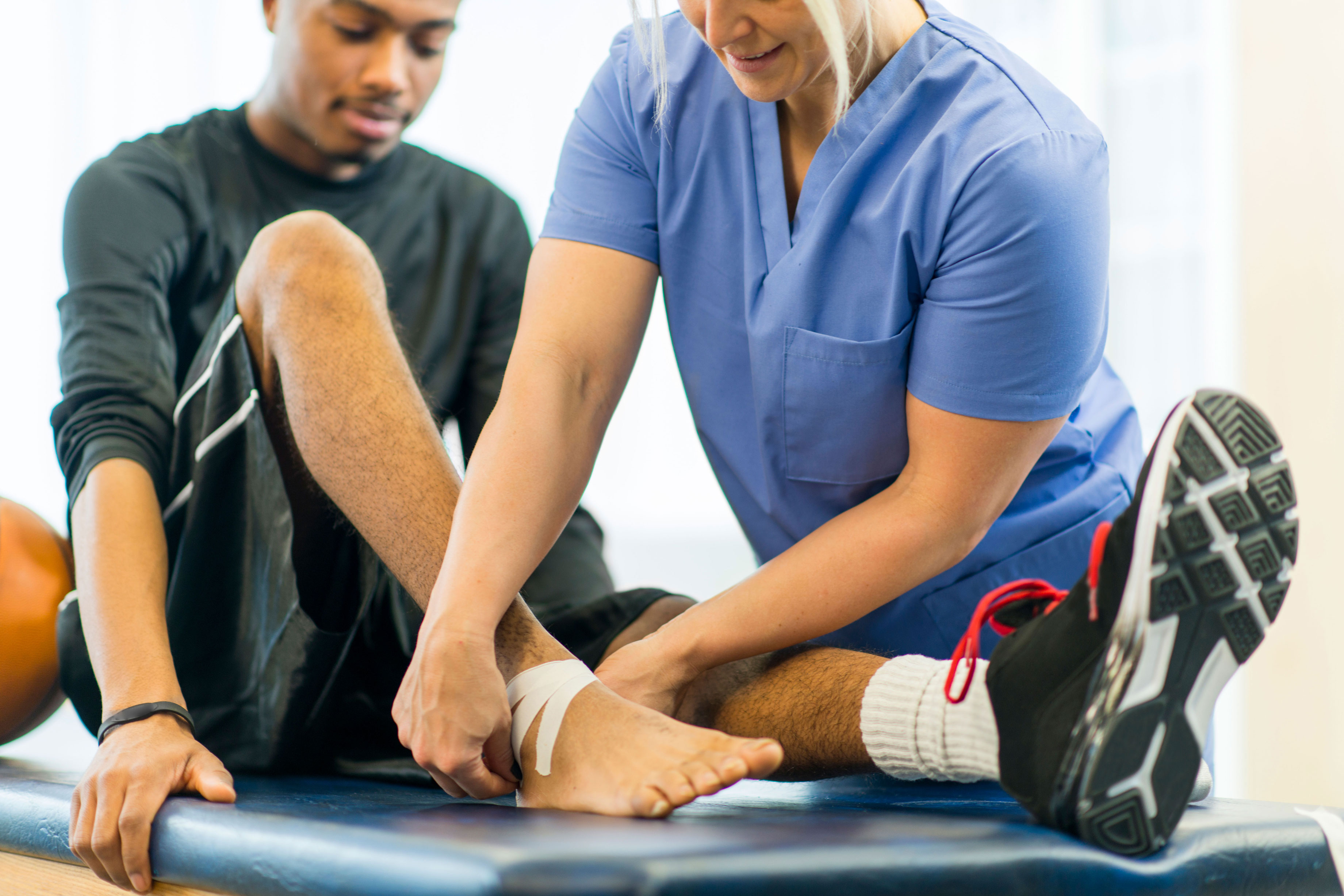 Physical therapist treating a leg injury