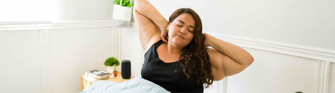 Overweight woman waking up in bed