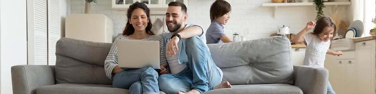 Young couple on couch looking at laptop