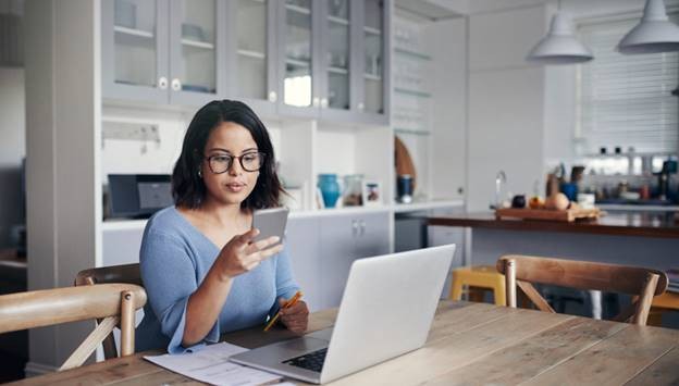 Woman on her phone with her laptop