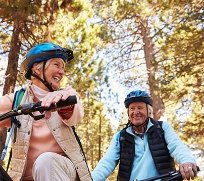 Man and woman riding bikes outside