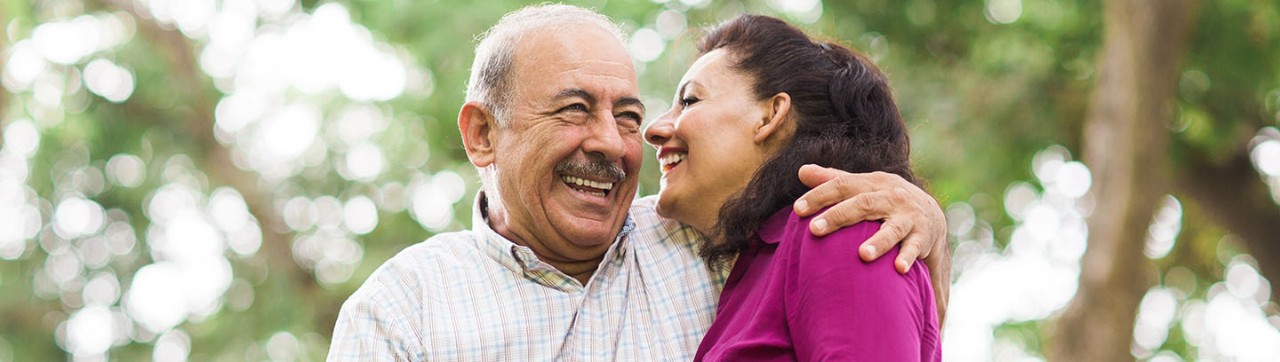 Older couple hugging and smiling.