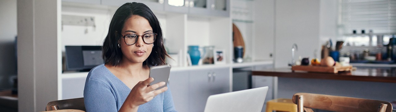 A woman looks at her phone as she checks in ahead of time for a visit with a physician