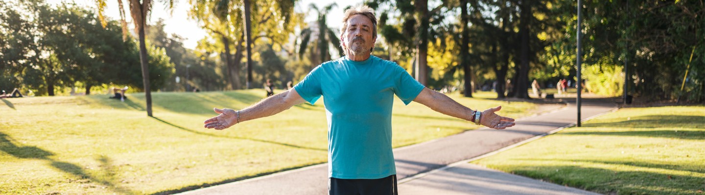 Man taking a deep breath in a park