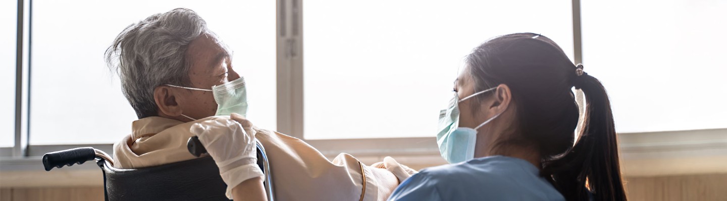 Senior male patient in wheelchair with female nurse